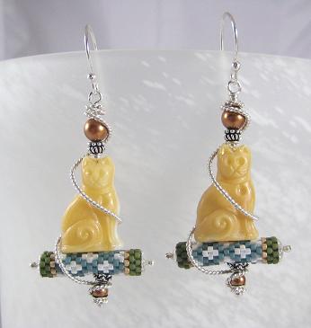 Carved cats on top of a seed beaded tube with sterling wire wrap